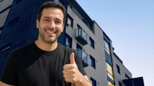מדביר בגן יבנה נותן אגודל למעלה על רקע בנייני מגורים