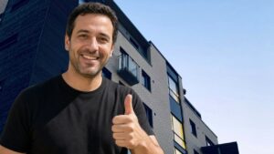 מדביר בגני תקווה נותן אגודל למעלה על רקע בנייני מגורים
