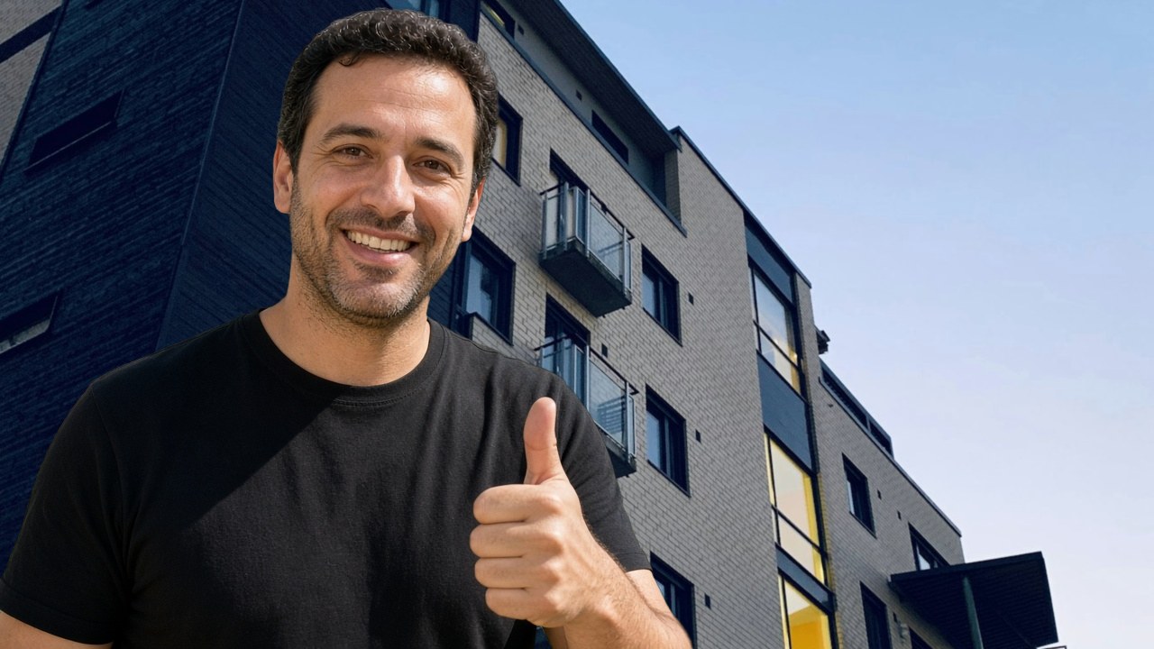 מדביר בקריית אונו נותן אגודל למעלה על רקע בנייני מגורים